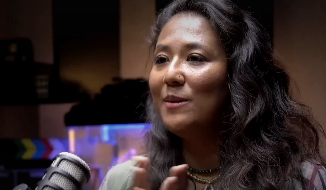 Noortasha Devi at the microphone, mid-sentence